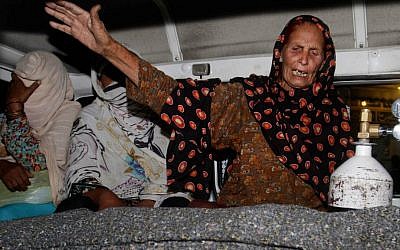 A family member of a pregnant woman who was stoned to death by her own family wails over her dead body in an ambulance at a local hospital in Lahore, Pakistan, Tuesday, May 27, 2014. (photo credit: AP/K.M. Chaudary)