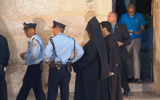 Police and priests outside the Church of the Holy Sepulchre in the Old City of Jerusalem. (screen capture: GPO)