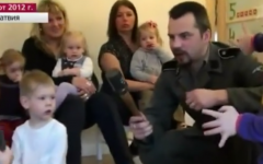 A Latvian man in Waffen SS uniform teaches toddlers at the Pucite nursery school about WWII-era weapons, March 2012 (photo credit: YouTube screenshot)