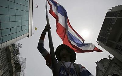 An anti-government protester waves a Thai national flag during a march through streets in Bangkok, Thailand, on Monday, May 19, 2014. (photo credit: AP Photo/Sakchai Lalit) An anti-government protester waves a Thai national flag during a march through streets in Bangkok, Thailand, on Monday, May 19, 2014. (photo credit: AP Photo/Sakchai Lalit)