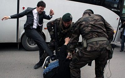 A person identified by Turkish media as Yusuf Yerkel, adviser to Turkish Prime Minister Recep Tayyip Erdogan, kicks a protester already held by special forces police members during Erdogan's visiting Soma, Turkey, on May 14, 2014. (photo credit: AP Photo/Depo Photos)