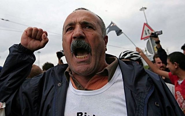 A man shouts as plain clothes security members try to detain a person who was reading as security close the city's landmark Taksim Square and Gezi Park on the first anniversary of last year's protests in Istanbul, Turkey, Saturday, May 31, 2014. (Photo credit: AP/Emrah Gurel)