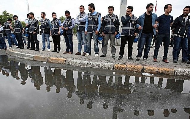 Turkish security members watch as they close the city's landmark Taksim Square and Gezi Park on the first anniversary of last year's protests in Istanbul, Turkey, Saturday, May 31, 2014. (Photo credit: AP/Emrah Gurel)