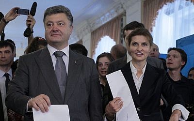 Ukrainian presidential candidate Petro Poroshenko, left, and his wife Maria, right, cast their ballots at a polling station during the presidential election in Kiev, Ukraine, Sunday, May 25, 2014. (photo credit: AP Photo/Sergei Chuzavkov)