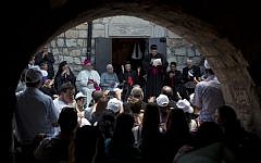 Cardinal Beshara Rai, the head of Lebanon’s Maronite Catholics, gathers with other clergy and supporters next to a church in the ruins of the village of Kufr Birim, northern Israel, Wednesday, May 28, 2014. It was one of two politically charged visits to disparate Maronite flocks in Israel Wednesday in a precedent-setting Holy Land pilgrimage overshadowed by criticism back home. (photo credit: AP Photo/Sebastian Scheiner)