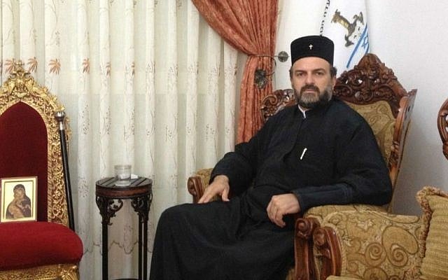 Father Gabriel Naddaf, in his living room, alongside a likeness of Mary, which, he believes, saved his life in a road accident in 2011. (Mitch Ginsburg/Times of Israel) Father Gabriel Naddaf, in his living room, alongside a likeness of Mary, which, he believes, saved his life in a road accident in 2011. (Mitch Ginsburg/Times of Israel)