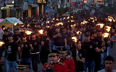 Palestinians hold torches marking the 66th anniversary of "Nakba," or “catastrophe” referring to their uprooting in the war over Israel's 1948 creation, in the West Bank city of Ramallah, Wednesday, May 14, 2014 (photo credit: AP/Majdi Mohammed) 