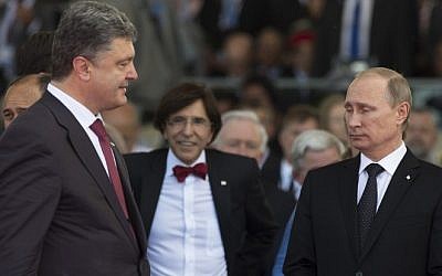 Ukraine's President-elect Petro Poroshenko (L) walks past Russia's President Vladimir Putin (R) during an international D-Day commemoration ceremony on the beach of Ouistreham, Normandy, on June 6, 2014, marking the 70th anniversary of the World War II Allied landings in Normandy. (photo credit: Alexander Zemlianichenko/AFP)