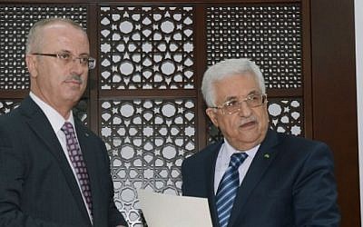 A handout picture released by the Palestinian Authority president's office shows Mahmoud Abbas (R) meeting with Palestinian premier Rami Hamdallah (L) in the West Bank city of Ramallah (photo credit: AFP PHOTO / PPO /HO)