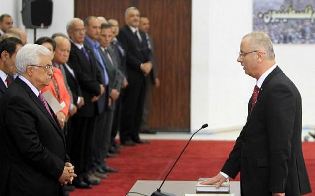 Palestinian Authority Prime Minister Rami Hamdallah (R) is sworn in along with the new Palestinian unity government in the presence of PA President Mahmoud Abbas (L) in the West Bank city of Ramallah, Monday, June 2, 2014 (photo credit: AFP/ABBAS MOMANI) Palestinian Authority Prime Minister Rami Hamdallah (R) is sworn in along with the new Palestinian unity government in the presence of PA President Mahmoud Abbas (L) in the West Bank city of Ramallah, Monday, June 2, 2014 (photo credit: AFP/ABBAS MOMANI)