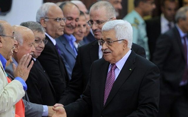 Palestinian Authority President Mahmoud Abbas and Prime Minister Rami Hamdallah greet the members of the new Palestinian unity government in the West Bank city of Ramallah, June 2, 2014. (Photo credit: AFP /ABBAS MOMANI) Palestinian Authority President Mahmoud Abbas and Prime Minister Rami Hamdallah greet the members of the new Palestinian unity government in the West Bank city of Ramallah, June 2, 2014. (Photo credit: AFP /ABBAS MOMANI)