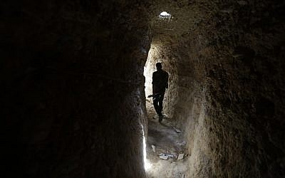 A Syrian army soldier makes his way in a tunnel reportedly previously used by rebel fighters in Jobar, a mostly rebel-held area on the eastern outskirts of Damascus on June 2, 2014. (photo credit: AFP/JOSEPH EID)