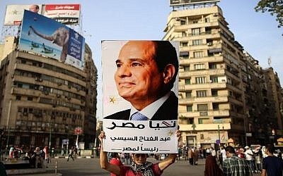 An Egyptian man holds up a portrait of ex-army chief Abdel Fattah el-Sisi as he celebrates in Cairo's Tahrir Square on June 3, 2014 after Sisi won 96.9 percent of votes in the country's presidential election (Photo credit: Mohamed el-Shahed/AFP)