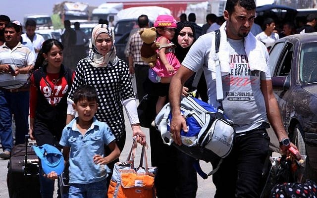 Iraqi families fleeing violence in the northern Nineveh province gather at a Kurdish checkpoint in Aski kalak, 40 kms West of Arbil, in the autonomous Kurdistan region, on June 10, 2014. (photo credit: AFP PHOTO/SAFIN HAMED) Iraqi families fleeing violence in the northern Nineveh province gather at a Kurdish checkpoint in Aski kalak, 40 kms West of Arbil, in the autonomous Kurdistan region, on June 10, 2014. (photo credit: AFP PHOTO/SAFIN HAMED)