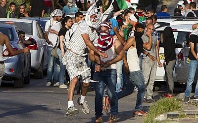 Arab Israeli protesters throw stones towards Israeli security forces (unseen) during clashes following a rally June 27, 2014 in the northern Israeli town of Umm al-Faham. (photo credit: AFP/Ahmad Gharabli)