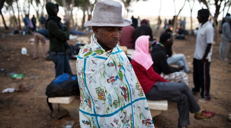 An African asylum seeker sits in a makeshift outdoor camp near Israel's Nitzana border crossing with Egypt on June 28, 2014. (photo credit: AFP/MENAHEM KAHANA) An African asylum seeker sits in a makeshift outdoor camp near Israel's Nitzana border crossing with Egypt on June 28, 2014. (photo credit: AFP/MENAHEM KAHANA)