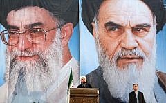 Iranian President Hassan Rouhani delivers a speech under portraits of Iran's supreme leader, Ayatollah Ali Khamenei (left) and Iran's founder of the Islamic Republic, Ayatollah Ruhollah Khomeini (right), on the eve of the 25th anniversary of the Islamic revolutionary leader Ayatollah Ruhollah Khomeini's death on June 3, 2014 (Photo credit: Atta Kenare/AFP)
