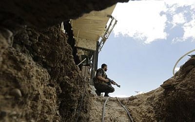 A Syrian army soldier secures the entrance of a tunnel reportedly dug by rebels fighters in Jobar, a mostly rebel-held area on the eastern outskirts of Damascus, on June 2, 2014. (photo credit: AFP/Joseph Eid)