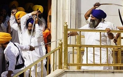 Members of a hardline Sikh group clash with guards of the Sikh’s holiest shrine, the Golden Temple, in Amritsar, India, Friday, June 6, 2014. Half a dozen people were wounded Friday as members of a Sikh group brandishing swords and wooden sticks clashed with guards at the shrine in India, an official said. The clash occurred during a ceremony marking the anniversary of the storming of the shrine by the Indian army in June 1984 in the northern city of Amritsar, said Kiran Jyoti Kaur, a Golden Temple management spokeswoman. (photo credit: AP Photo/Prabhjot Gill) Members of a hardline Sikh group clash with guards of the Sikh’s holiest shrine, the Golden Temple, in Amritsar, India, Friday, June 6, 2014. Half a dozen people were wounded Friday as members of a Sikh group brandishing swords and wooden sticks clashed with guards at the shrine in India, an official said. The clash occurred during a ceremony marking the anniversary of the storming of the shrine by the Indian army in June 1984 in the northern city of Amritsar, said Kiran Jyoti Kaur, a Golden Temple management spokeswoman. (photo credit: AP Photo/Prabhjot Gill)