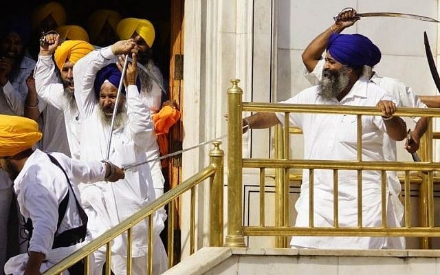 Members of a hardline Sikh group clash with guards of the Sikh’s holiest shrine, the Golden Temple, in Amritsar, India, Friday, June 6, 2014. Half a dozen people were wounded Friday as members of a Sikh group brandishing swords and wooden sticks clashed with guards at the shrine in India, an official said. The clash occurred during a ceremony marking the anniversary of the storming of the shrine by the Indian army in June 1984 in the northern city of Amritsar, said Kiran Jyoti Kaur, a Golden Temple management spokeswoman. (photo credit: AP Photo/Prabhjot Gill) Members of a hardline Sikh group clash with guards of the Sikh’s holiest shrine, the Golden Temple, in Amritsar, India, Friday, June 6, 2014. Half a dozen people were wounded Friday as members of a Sikh group brandishing swords and wooden sticks clashed with guards at the shrine in India, an official said. The clash occurred during a ceremony marking the anniversary of the storming of the shrine by the Indian army in June 1984 in the northern city of Amritsar, said Kiran Jyoti Kaur, a Golden Temple management spokeswoman. (photo credit: AP Photo/Prabhjot Gill)