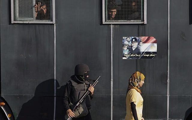 An Egyptian woman walks past a vehicle carrying anti-riot police officers deployed to secure a protest against sexual harassment in Cairo, Egypt, Saturday, June 14, 2014 (photo credit: AP/Amr Nabil) An Egyptian woman walks past a vehicle carrying anti-riot police officers deployed to secure a protest against sexual harassment in Cairo, Egypt, Saturday, June 14, 2014 (photo credit: AP/Amr Nabil)