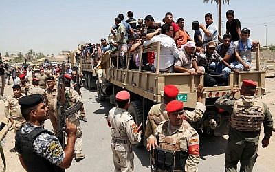 Iraqi men board military trucks to join the Iraqi army at the main recruiting center in Baghdad, Iraq, Saturday, June. 14, 2014, after authorities urged Iraqis to help battle insurgents. (Photo credit: AP/Karim Kadim)