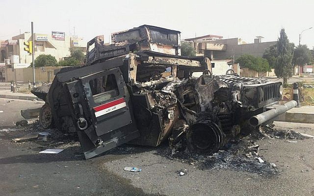 An Iraqi army armored vehicle is seen burned on a street of the northern city of Mosul, Iraq, Thursday, June 12, 2014 (photo credit: AP) An Iraqi army armored vehicle is seen burned on a street of the northern city of Mosul, Iraq, Thursday, June 12, 2014 (photo credit: AP)