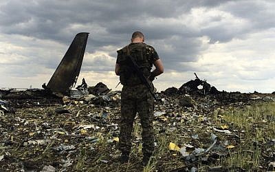 A pro-Russian fighter guards the site of remnants of a downed Ukrainian army aircraft Il-76 at the airport near Luhansk, Ukraine, Saturday, June 14, 2014 (photo credit: AP/Evgeniy Maloletka)