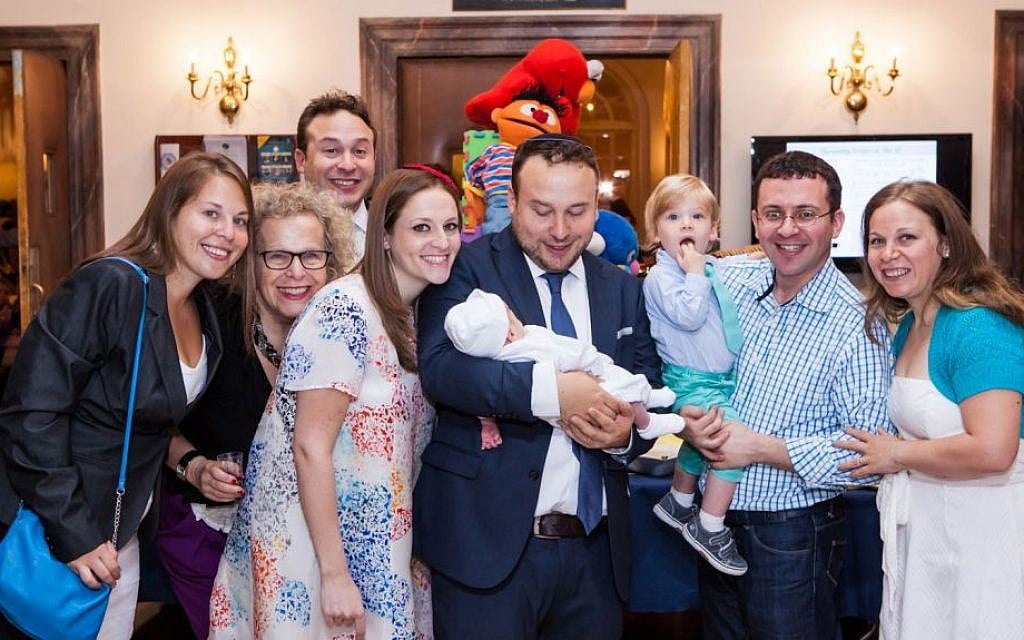 Seth Galena and Hindy Poupko, on his right shoulder, celebrate the birth of their son Akiva at his bris, June 15, 2014. (Piha Studio/via JTA) Seth Galena and Hindy Poupko, on his right shoulder, celebrate the birth of their son Akiva at his bris, June 15, 2014. (Piha Studio/via JTA)