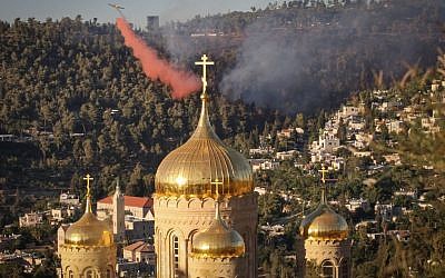 A firefighting plane tries to extinguish a large brush fire behind the the Russian Church in the Jerusalem neighborhood of Ein Kerem, Wednesday, June 25, 2014. (photo credit: Flash90)