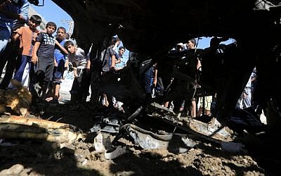 Palestinians gather around wreckage after an airstrike in the Shati refugee camp in Gaza City on Friday, June 27, 2014. (Photo credit: Wissam Nassar/Flash90) Palestinians gather around wreckage after an airstrike in the Shati refugee camp in Gaza City on Friday, June 27, 2014. (Photo credit: Wissam Nassar/Flash90)