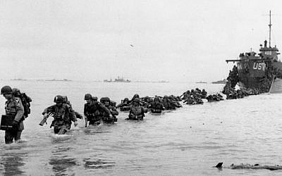 US reinforcements wade through the surf from a landing craft in the days following D-Day and the Allied invasion of Nazi-occupied France at Normandy in June 1944 during World War II. (AP Photo/Bert Brandt, File)