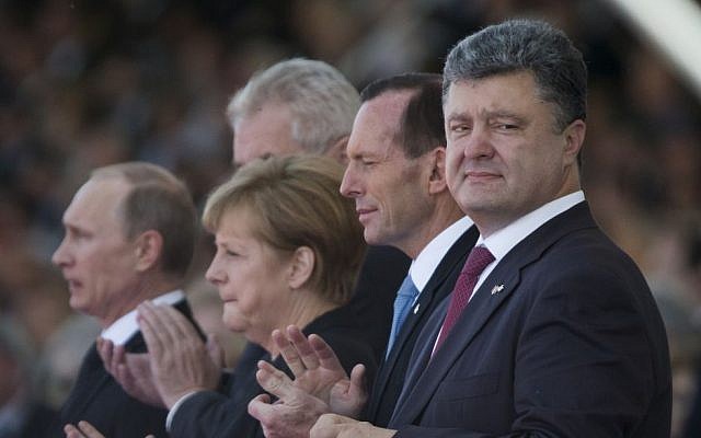 Ukraine's President-elect Petro Poroshenko, right, German Chancellor Angela Merkel, second left, and Russian President Vladimir Putin, left, applaud during the commemoration of the 70th anniversary of the D-Day in Ouistreham, western France, Friday, June 6, 2014. (photo credit: AP/Alexander Zemlianichenko) Ukraine's President-elect Petro Poroshenko, right, German Chancellor Angela Merkel, second left, and Russian President Vladimir Putin, left, applaud during the commemoration of the 70th anniversary of the D-Day in Ouistreham, western France, Friday, June 6, 2014. (photo credit: AP/Alexander Zemlianichenko)