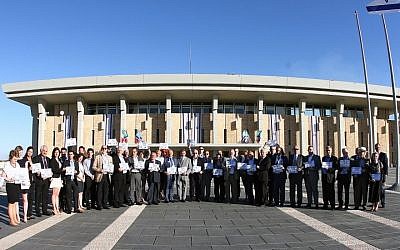 A delegation of European Jewish community leaders holds signs reading 'Bring back our boys' at the Knesset in Jerusalem on Wednesday, June 25, 2014 (photo credit: Yoel Balinko/ Israeli Jewish Congress)