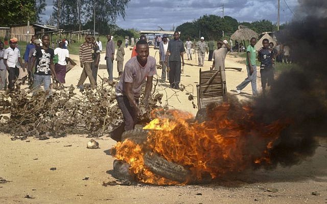 Residents barricade a road with burning tyres and other roadblocks as they protest against the recent killings and what they claimed was the government's failure to provide them with enough security, in the village of Kibaoni just outside the town of Mpeketoni, about 60 miles (100 kilometers) from the Somali border on the coast of Kenya Tuesday, June 17, 2014.  (photo credit: AP Photo)