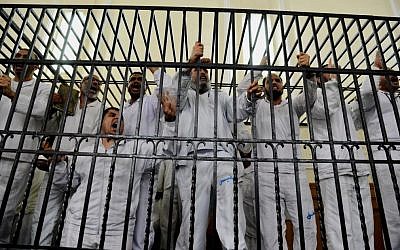 Illustrative: Supporters of Egypt's ousted president Mohammed Morsi charged with violence chant slogans against the Egyptian military during a trial in Alexandria, Egypt, on Saturday, March 29, 2014. (photo credit: AP/Heba Khamis/File)
