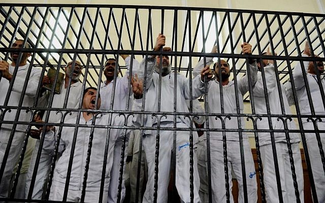 Illustrative: Supporters of Egypt's ousted president Mohammed Morsi charged with violence chant slogans against the Egyptian military during a trial in Alexandria, Egypt, on Saturday, March 29, 2014. (photo credit: AP/Heba Khamis/File) Illustrative: Supporters of Egypt's ousted president Mohammed Morsi charged with violence chant slogans against the Egyptian military during a trial in Alexandria, Egypt, on Saturday, March 29, 2014. (photo credit: AP/Heba Khamis/File)