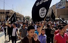 Demonstrators chant slogans to support ISIL as they carry flags in front of the provincial government headquarters in Mosul, 225 miles (360 kilometers) northwest of Baghdad, Iraq, on June 16, 2014. (photo credit: AP)