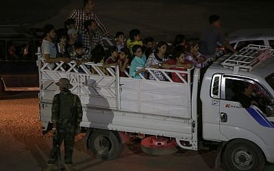 Fleeing Iraqi citizens from Mosul and other northern towns sit on a truck as they cross to secure areas at a Kurdish security forces checkpoint, in the Khazer area between the Iraqi city of Mosul and the Kurdish city of Irbil, northern Iraq, Wednesday June 25, 2014. (photo credit: AP Photo/Hussein Malla)
