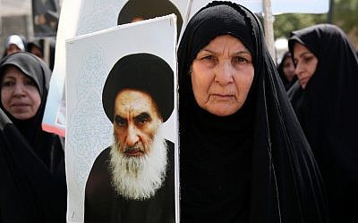An Iraqi woman living in Iran holds a poster of the Grand Ayatollah Ali al-Sistani, Iraq's top Shi'ite cleric, in a demonstration against Sunni militants of the al-Qaeda-inspired Islamic State of Iraq and the Levant, or ISIL, and to support Ayatollah al-Sistani, in Tehran, Iran. (photo credit: AP/Ebrahim Noroozi)