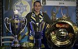 Maccabi Tel Aviv's former head coach David Blatt poses for photographers with the Israeli cup, European club champions cup and the Israeli club champions trophy after a news conference in Tel Aviv, Israel,Thursday, June 12, 2014. (photo credit: AP/Ariel Schalit)