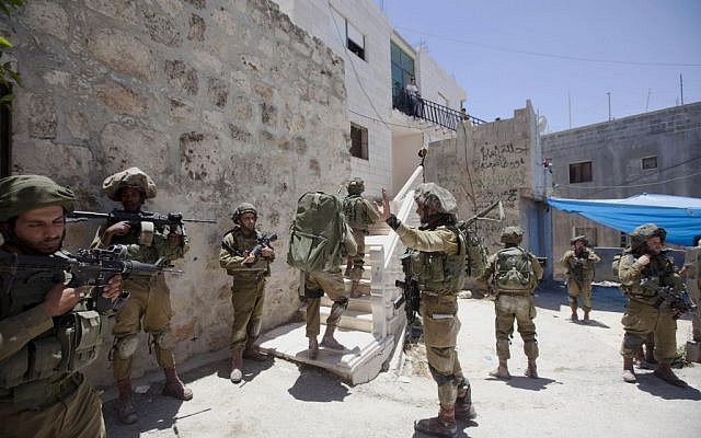 Israeli soldiers patrol during a military operation to search for three missing teenagers outside the West Bank city of Hebron, Sunday, June 15, 2014. (photo credit: AP/Majdi Mohammed) Israeli soldiers patrol during a military operation to search for three missing teenagers outside the West Bank city of Hebron, Sunday, June 15, 2014. (photo credit: AP/Majdi Mohammed)