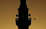 A bird flies towards the minaret of a mosque in the West Bank refugee camp of Jenin, June 28, 2014. (photo credit: AP/Mohammed Ballas)