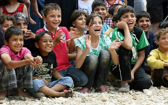 In this June 6, 2014 photo, Syrian refugee children smile while watching members of "Clowns Without Borders" perform at a Syrian refugee camp in the eastern town of Chtoura, in Bekaa valley, Lebanon. (AP Photo/Bilal Hussein)