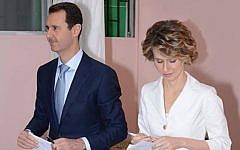 In this photo released by the Syrian official news agency SANA, Syrian President Bashar Assad, left, and first lady Asma Assad, right, leave a voting booth to cast their vote at a polling center, in Damascus, Syria, Tuesday June 3, 2014.(Photo credit:AP/SANA)