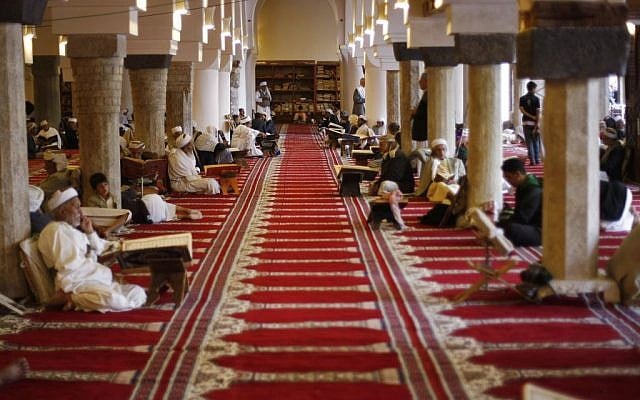 Yemeni men read verses of the Quran, Islam's holy book, on the first day of the holy month of Ramadan in the Grand Mosque in the Old City of Sanaa, Yemen, Saturday, June 28, 2014. (photo credit: AP/Hani Mohammed)