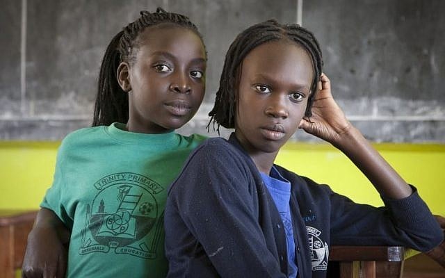 Two South Sudanese teenagers who previously lived in Israel listen to their friends reminisce about their time in Tel Aviv, in a classroom at the Trinity boarding school where they now live in Kampala, Uganda, April 9, 2014. (AP Photo/Rebecca Vassie)