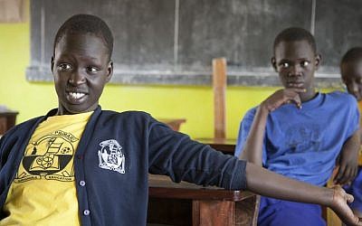 South Sudanese teenager Asunta Atoch, 16, left, who previously lived in Israel listens to her friends talk about their time in the country, in a classroom at the Trinity boarding school where they now live in Kampala, Uganda, April 9, 2014. (AP Photo/Rebecca Vassie)