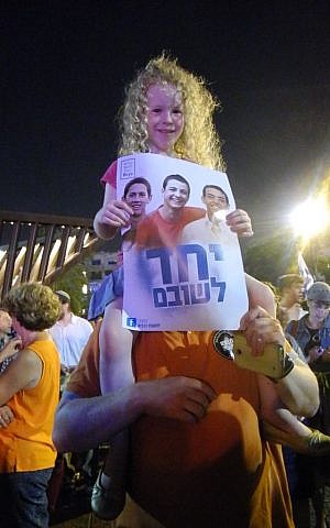 Six-year-old Uriya Noy, sitting on top of her father's shoulders at a rally on Sunday in Rabin Square (photo credit: Melanie Lidman/Times of Israel)