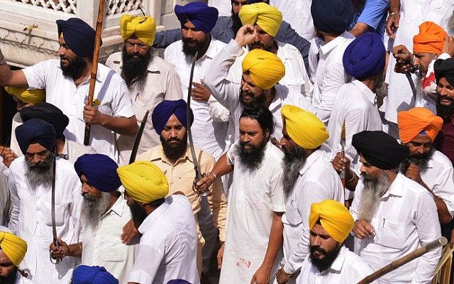 Indian Sikhs hold swords during clashes with activists during a ceremony to mark the 30th anniversary of the storming of the Golden Temple in Amritsar by the Indian army, June 6, 2014 (photo credit: AFP, Narinder Nanu)